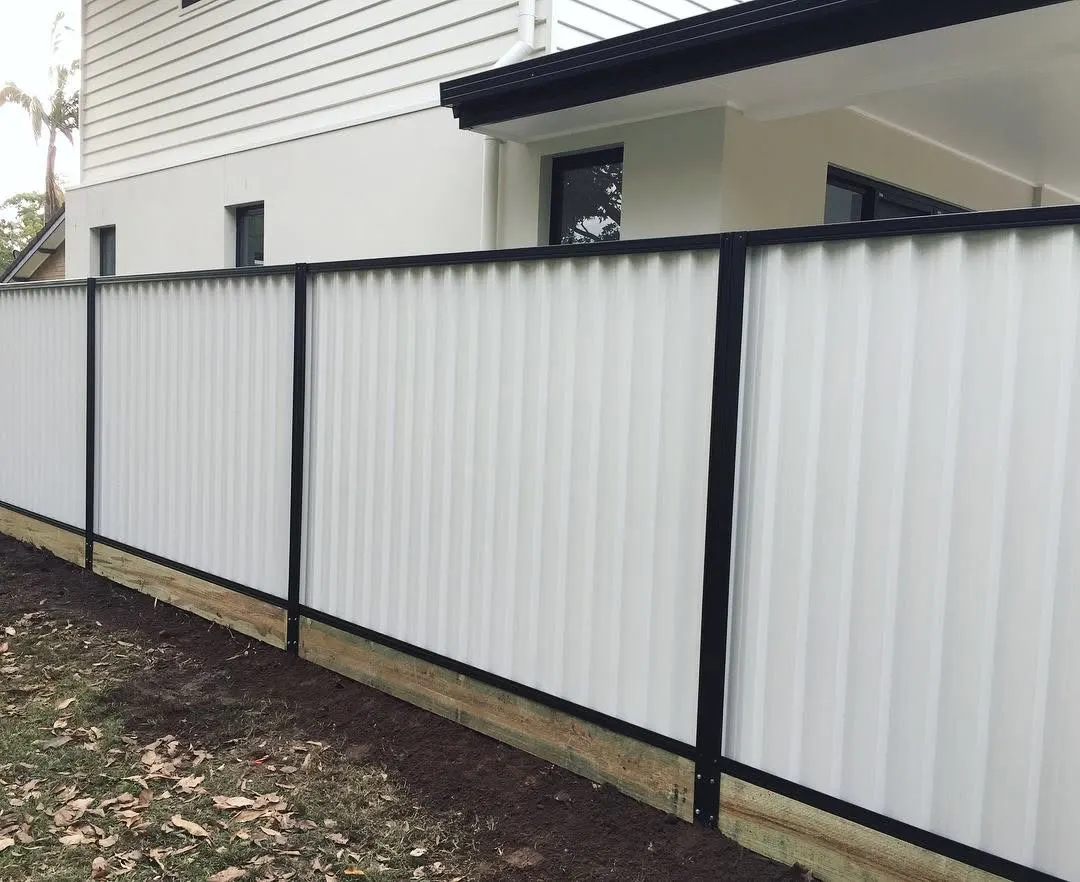 White Colorbond boundary fence with contrasting dark posts