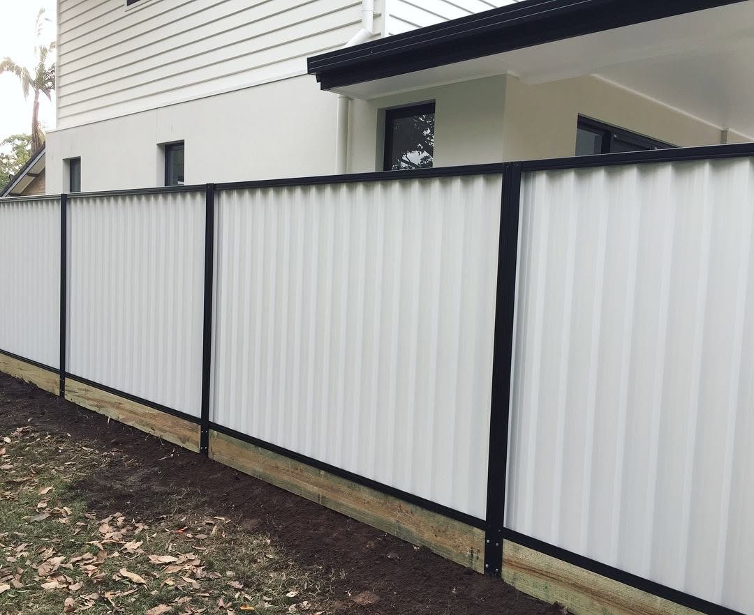 White Colorbond boundary fence with contrasting dark posts