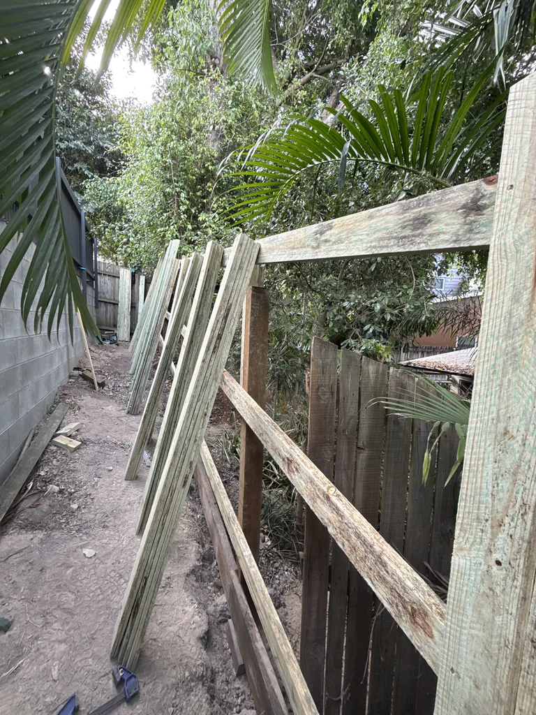 Timber fence being constructed beside a residential property